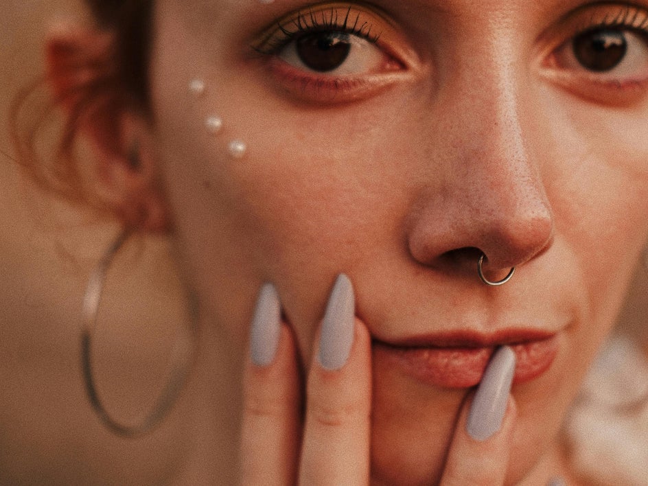 before: close up portrait of woman with long nails and playful makeup